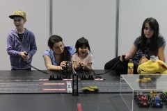 Kinder und Eltern spielen mit Slot cars aus LEGO Bausteinen